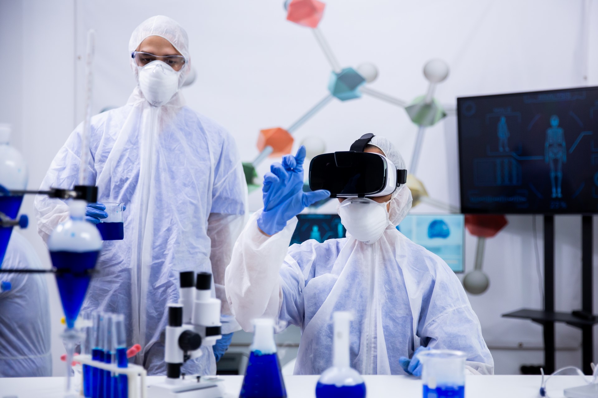 female-scientist-working-with-virtual-reality-goggles-research-laboratory-with-her-assistant-background